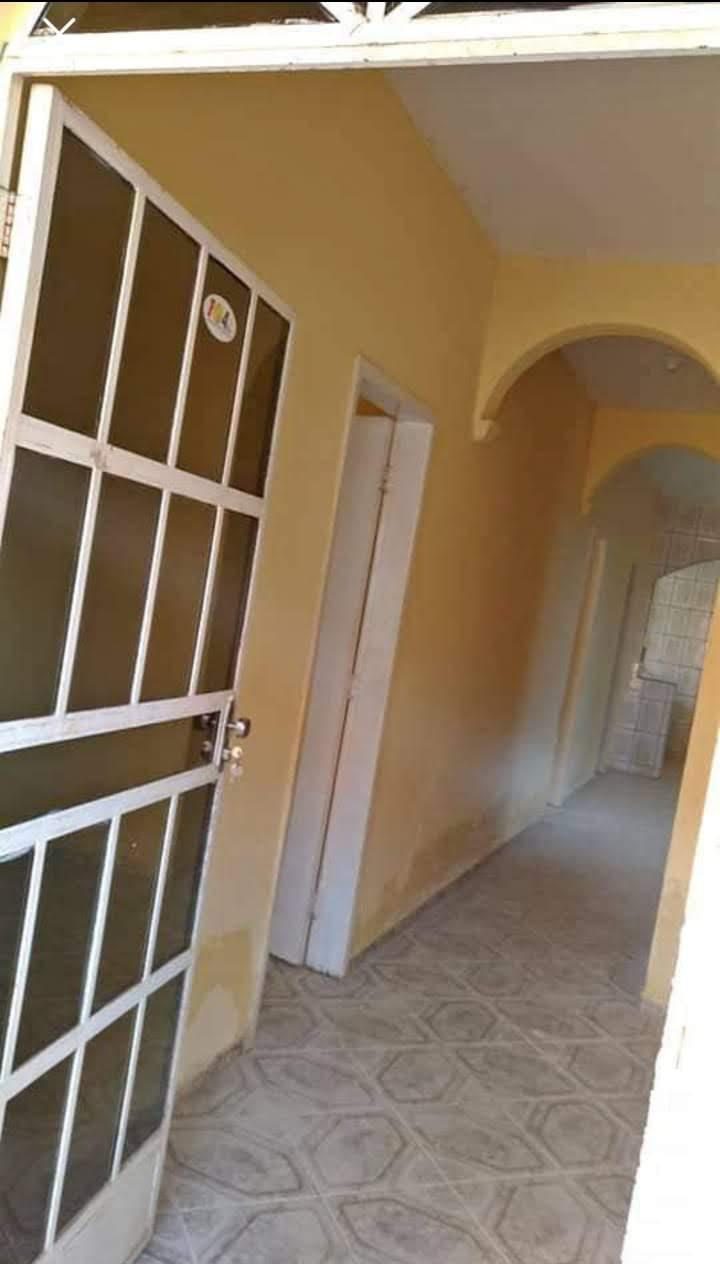 Corredor interior com arco, paredes pintadas e pavimento cerâmico