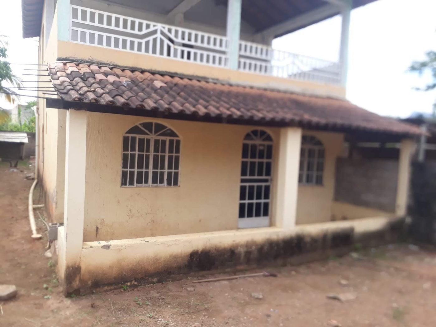 Traseiras de uma moradia com alpendre e janelas em arco